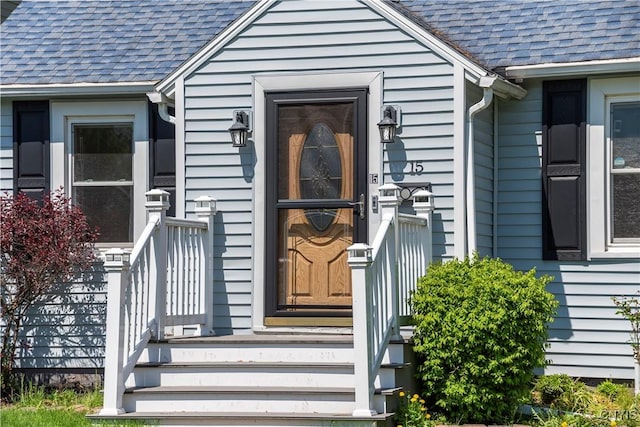 doorway to property with a shingled roof