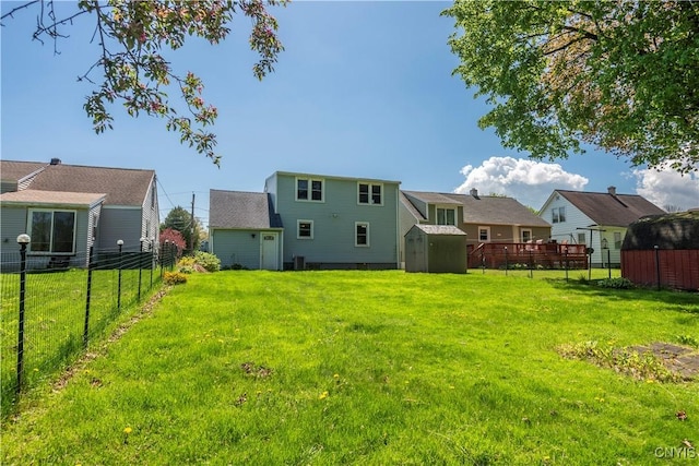 view of yard with a shed, a residential view, a fenced backyard, and an outdoor structure