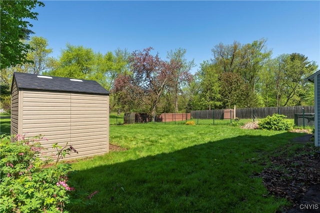 view of yard featuring a shed, fence, and an outdoor structure