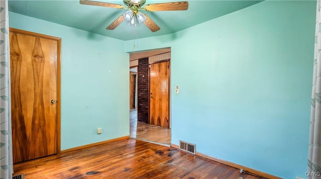 unfurnished bedroom with visible vents, ceiling fan, baseboards, and hardwood / wood-style flooring