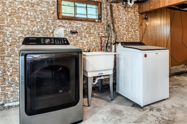 laundry area featuring laundry area, a sink, and washer and clothes dryer