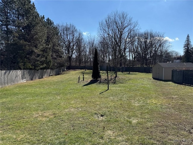 view of yard featuring a fenced backyard, an outdoor structure, and a storage shed