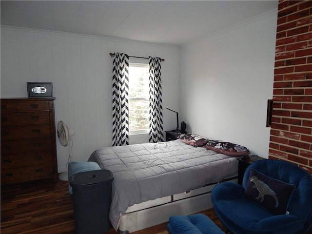 bedroom with ornamental molding and wood finished floors