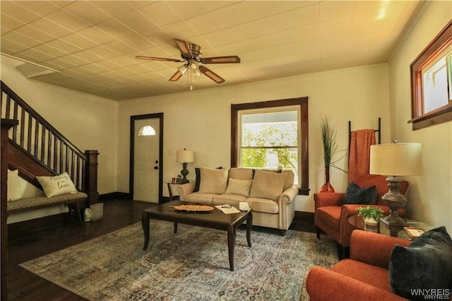 living room with stairs, wood finished floors, and a ceiling fan