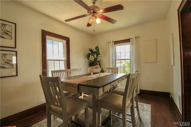 dining room featuring a ceiling fan, a textured ceiling, baseboards, and dark wood-type flooring