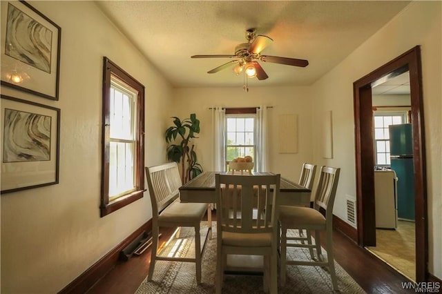 dining area featuring a ceiling fan, baseboards, visible vents, and wood finished floors