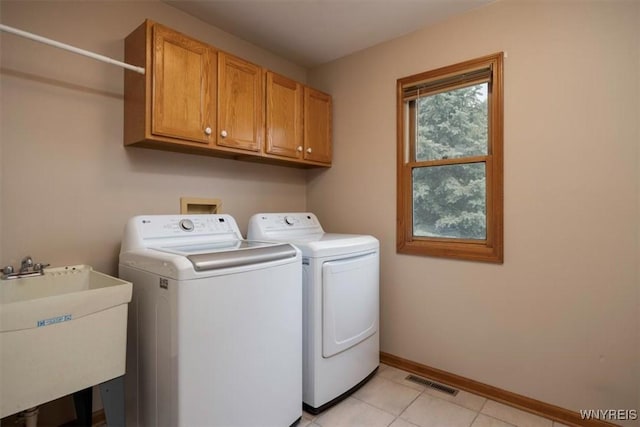 laundry area with separate washer and dryer, a sink, visible vents, baseboards, and cabinet space