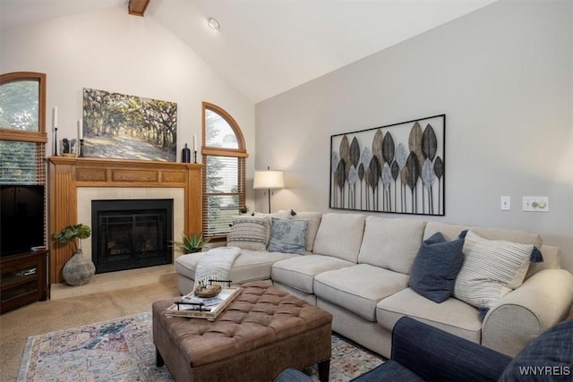 living room with high vaulted ceiling, carpet, beam ceiling, and a tiled fireplace