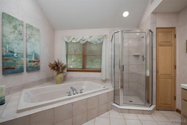 bathroom featuring lofted ceiling, vanity, a shower stall, a bath, and tile patterned floors