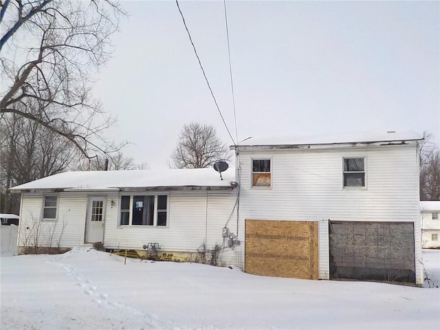 snow covered house featuring an attached garage