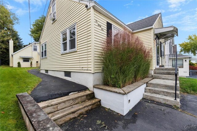 view of side of home with a yard