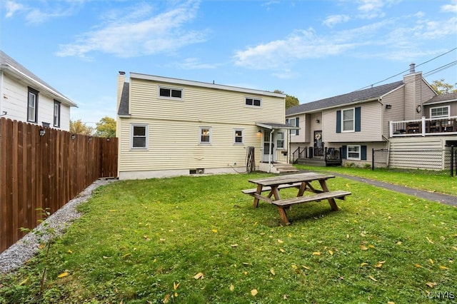 rear view of house with a yard and fence