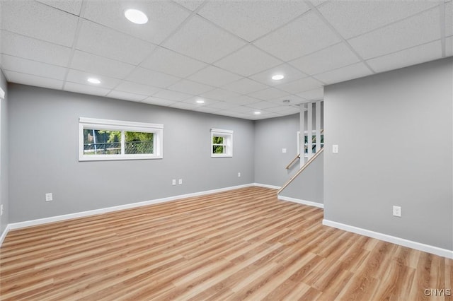 below grade area featuring recessed lighting, a paneled ceiling, light wood-style flooring, and baseboards