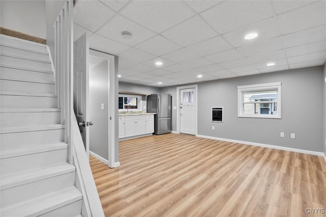 interior space featuring freestanding refrigerator, light wood-style flooring, and baseboards