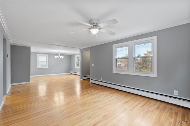 spare room with light wood finished floors, a baseboard radiator, ornamental molding, and ceiling fan with notable chandelier