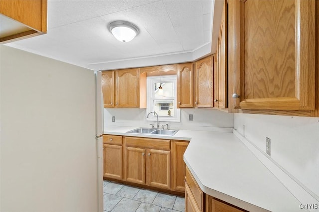 kitchen featuring light tile patterned floors, light countertops, and a sink