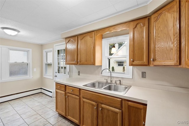 kitchen featuring brown cabinets, a baseboard heating unit, light countertops, and a sink