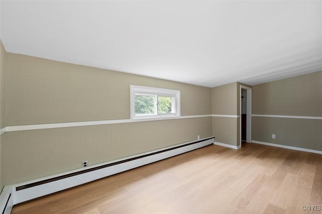 spare room featuring light wood-type flooring and baseboard heating