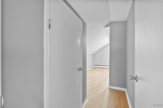 hallway featuring a baseboard radiator, baseboards, vaulted ceiling, and wood finished floors