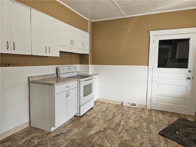 kitchen featuring white cabinets, white electric stove, visible vents, and baseboards