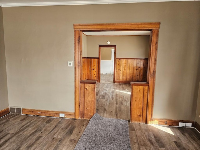 interior space with visible vents, ornamental molding, wood finished floors, and wainscoting