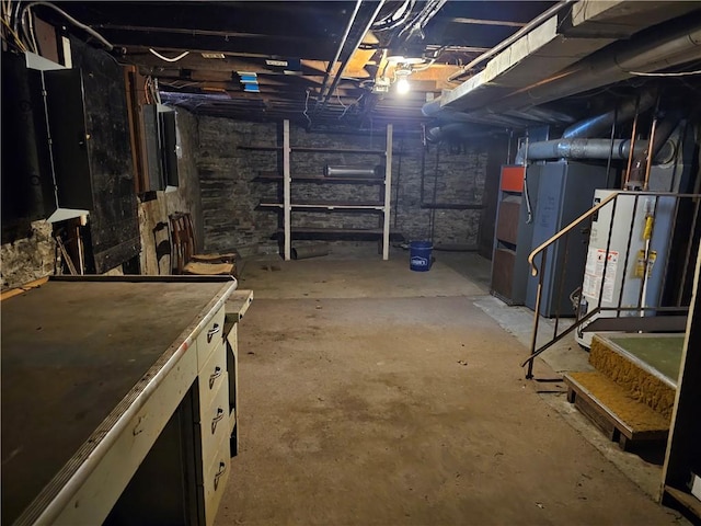 unfinished basement featuring water heater, electric panel, and heating unit