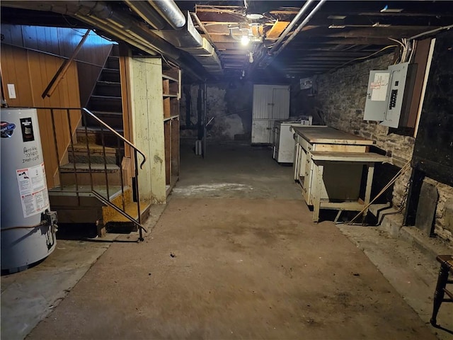 unfinished basement featuring washer / dryer, electric panel, stairway, and gas water heater