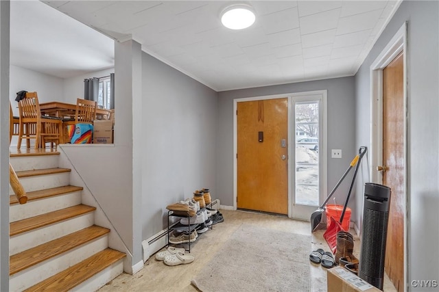 entrance foyer featuring a baseboard heating unit, baseboards, stairway, and ornamental molding