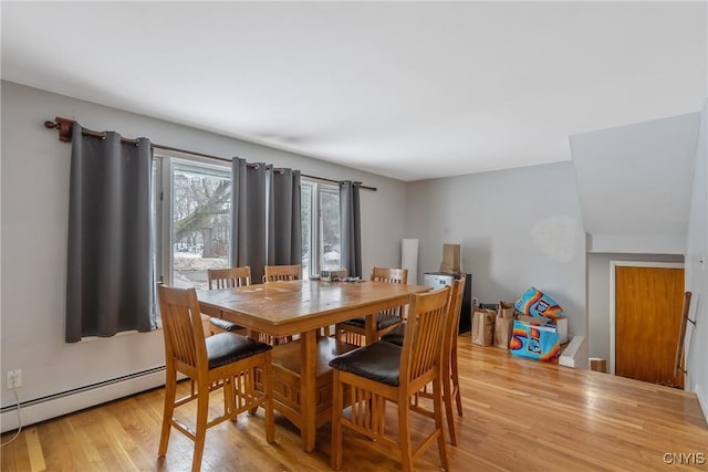 dining space featuring a baseboard heating unit and light wood-style flooring