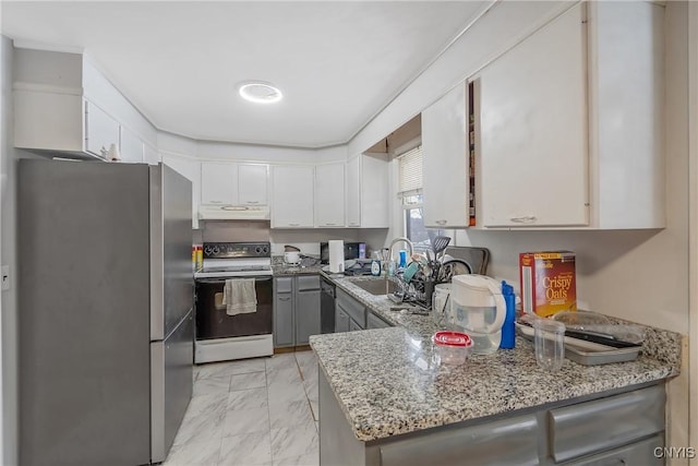 kitchen featuring under cabinet range hood, range with electric cooktop, a sink, marble finish floor, and freestanding refrigerator