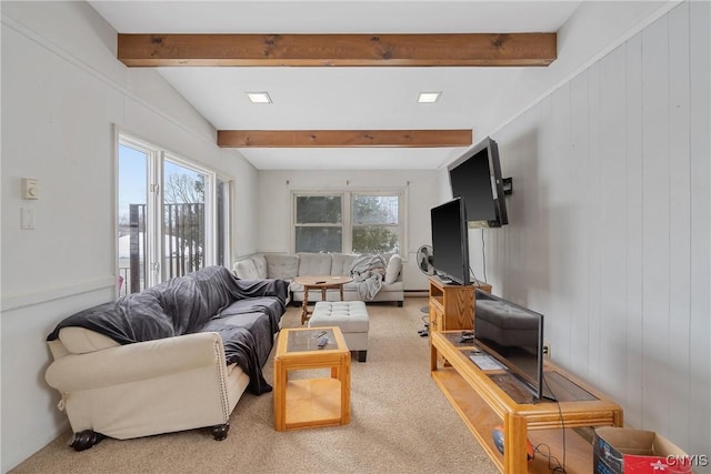 living room with a wealth of natural light, beam ceiling, and light colored carpet