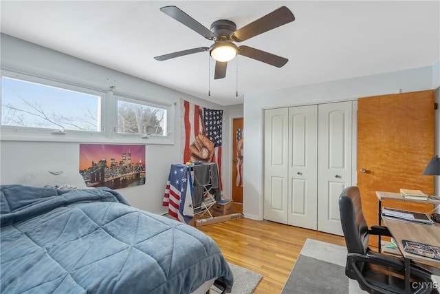 bedroom with light wood finished floors, a ceiling fan, and a closet