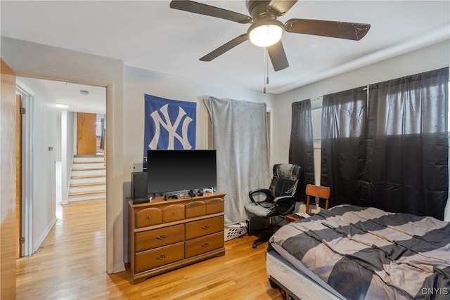 bedroom featuring baseboards, a ceiling fan, and light wood-style floors