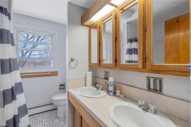 bathroom featuring double vanity, a baseboard radiator, a sink, and toilet