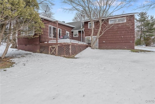 snow covered property with a wooden deck