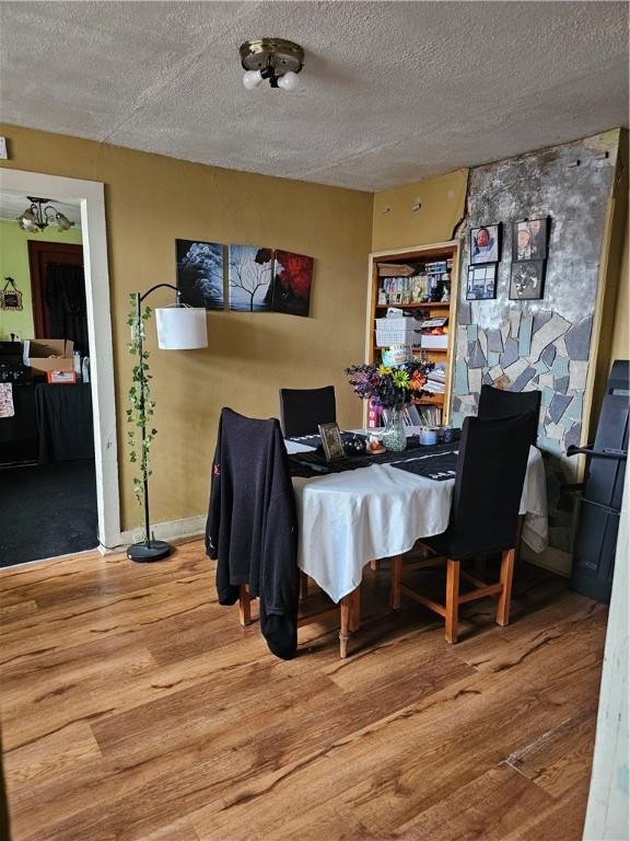 dining area with a textured ceiling and wood finished floors