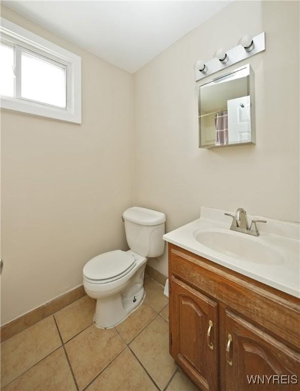 bathroom featuring tile patterned floors, vanity, toilet, and baseboards