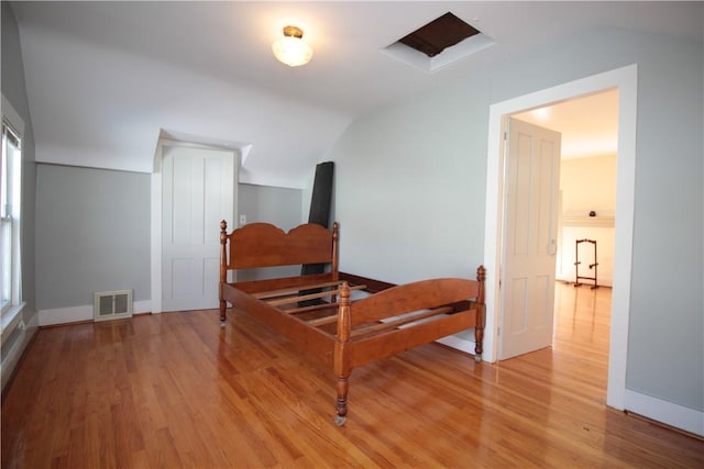 bedroom featuring light wood-type flooring, visible vents, and baseboards