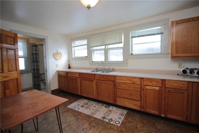 kitchen featuring brown cabinetry, a sink, and light countertops