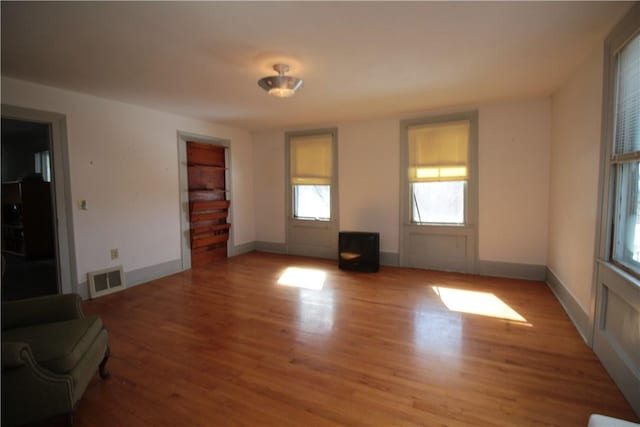 unfurnished living room with baseboards, visible vents, and light wood-style floors