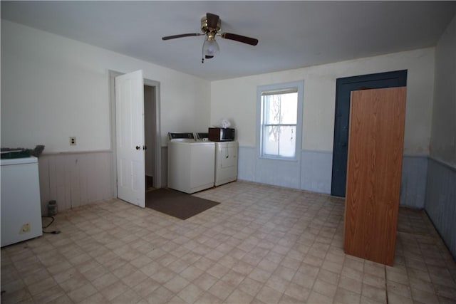 washroom with laundry area, washer and clothes dryer, a ceiling fan, a wainscoted wall, and tile patterned floors