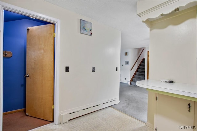 corridor featuring a baseboard radiator and stairway