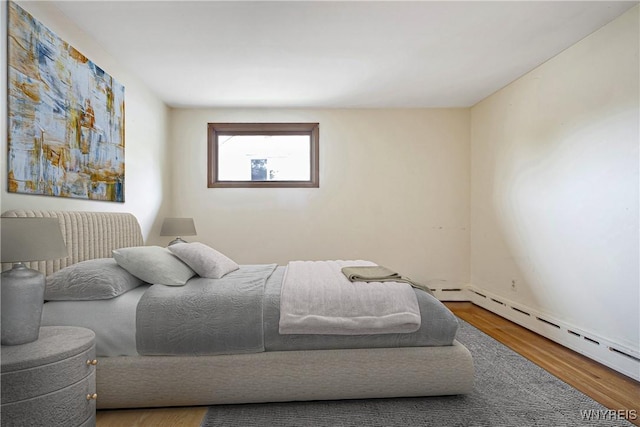 bedroom featuring a baseboard radiator and wood finished floors