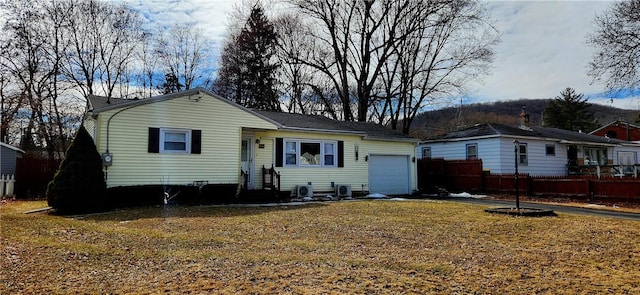 ranch-style house with a front yard, fence, and an attached garage