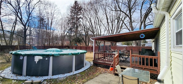 exterior space featuring a fenced in pool, outdoor dining space, a fenced backyard, and a wooden deck