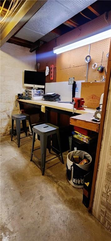 bar featuring a workshop area and unfinished concrete floors