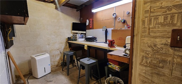 interior space featuring concrete block wall, concrete floors, and a workshop area