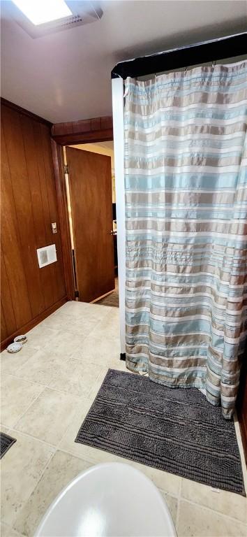 bathroom featuring a shower with curtain and wooden walls