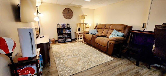 living room featuring wood finished floors and a paneled ceiling