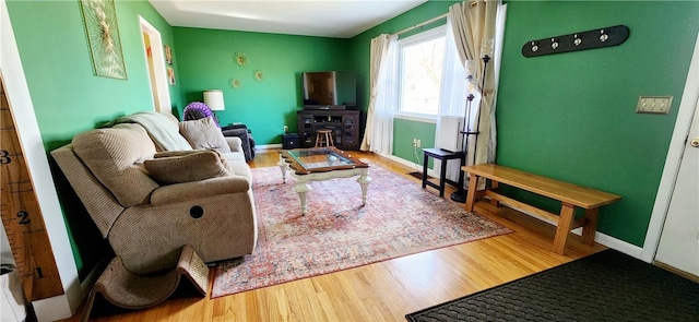 living area featuring baseboards and wood finished floors